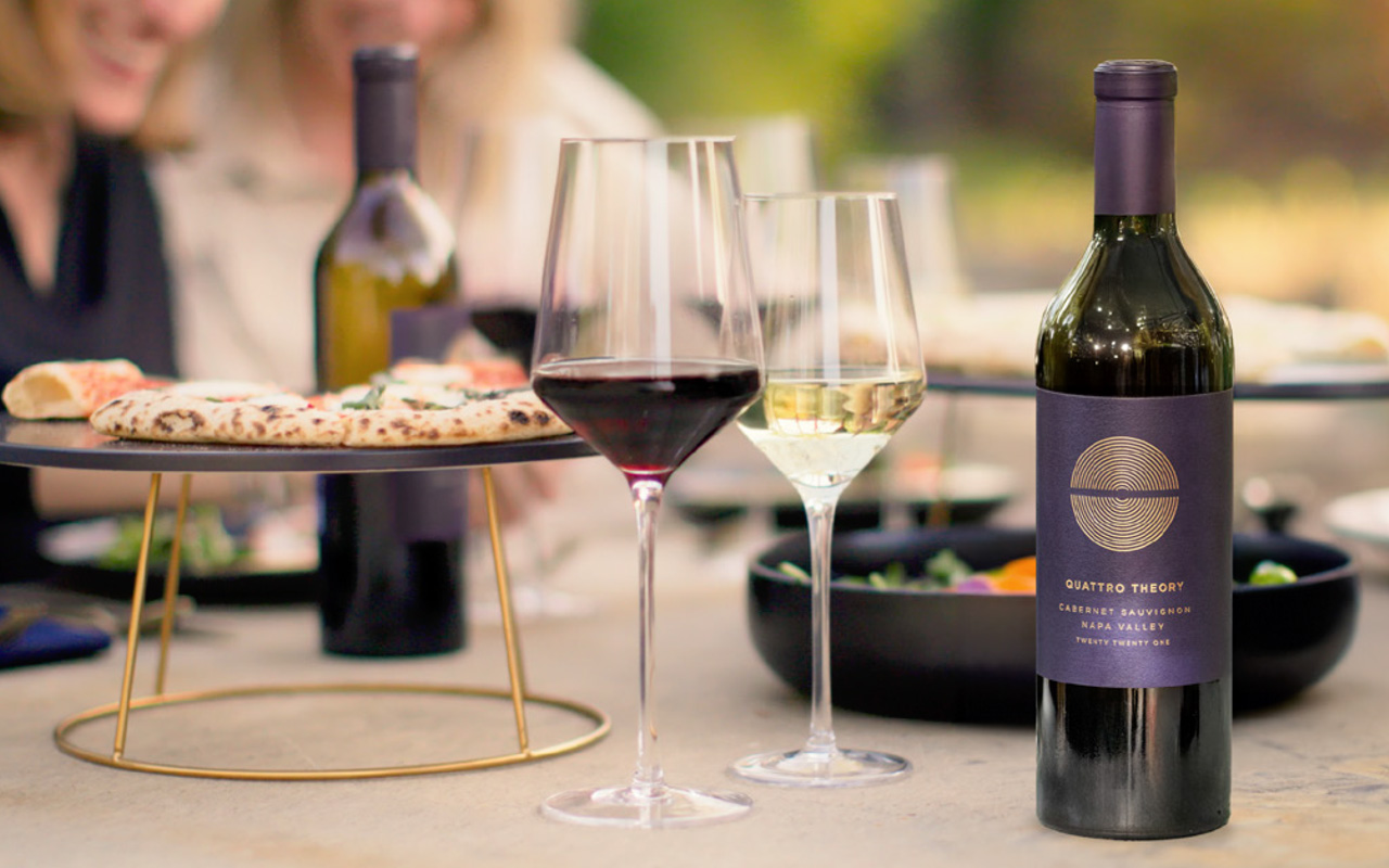 Table set up with pizza and wine bottles